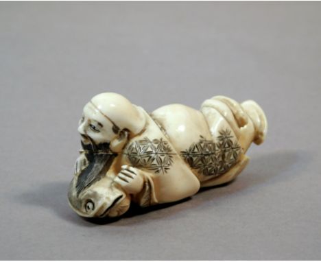 A 19th century Japanese netsuke from Meiji period. Signed on the base. In carved elephant ivoryportraying Daikoku lying on Na