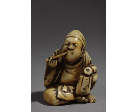 A 19th century Japanese netsuke. Signed Tomomasa, In carved elephant ivory portraying 'Eji' sat on the floor, smoking in his 