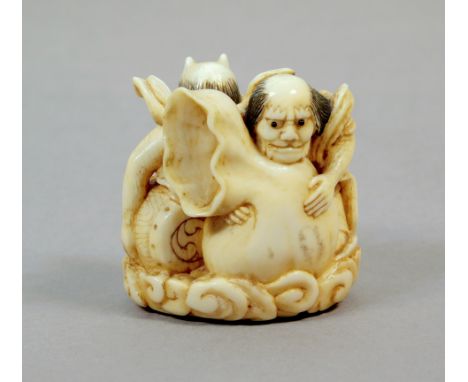 A 19th century Japanese netsuke from Edo period. Not signed. In carved elephant ivory portraying two ONis over the clouds, on