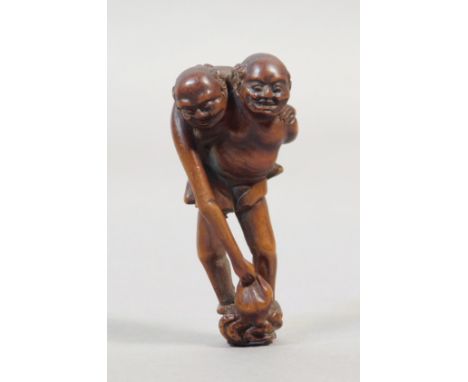A mid 19th century Japanese netsuke from Edo period. Not signed. In carved wood portraying a standing 'Ashinaga' carrying on 