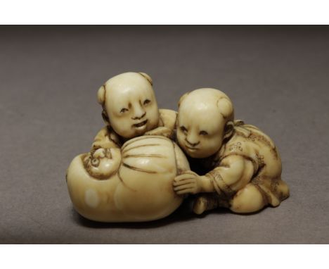  A Japanese netsuke from Edo period, Tokio,1820-1880. Signed Hikaku on the base. In carved elephant ivory portraying a group 