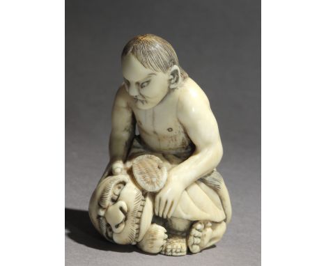An early 19th century Japanese netsuke from Meiji period. Not signed. In carved elephant ivory portrayinf a fighter subdueing