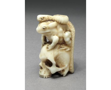 A 19th Japanese netsuke. Not signed. In carved hippo ivory portraying a Vanitas, where a frog and a snake are resting over th