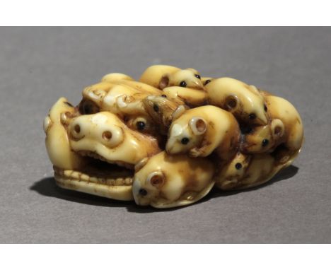 A mid 19th century Japanese netsuke from Edo period. Signed Ikko on the base. In carved ivory with horn eyes portraying a gro