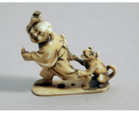 A 19th century Japanese netsuke from Meiji period. Not signed. In carved elephant ivory portrayinga Karako with a dog running