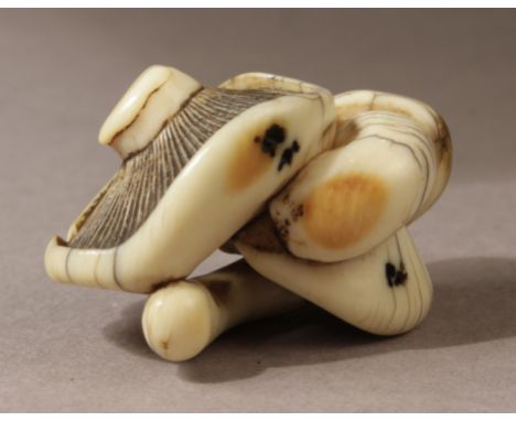 A Japanese netsuke from Edo period circa 1800. Not signed. In carved ivory in the style of Garaku or Raku portraying a group 