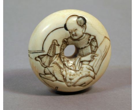 A 19th century Japanese manju type netsuke from Meiji period. Not signed. In carved elephant ivory portraying a karako with a