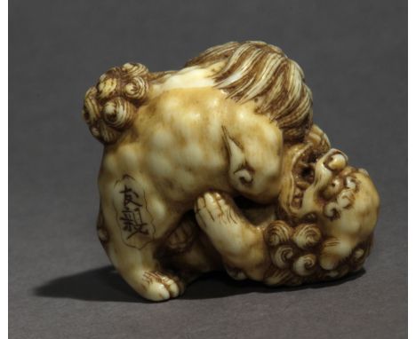 An early 19th century Japanese netsuke from Edo period. Signed Tomochika on the base. In carved elephant ivory portraying two