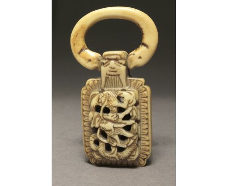 A Japanese netsuke-pendant from Edo period. Not signed. In carved elephatn ivory portraying a rectangular shaped pendant with