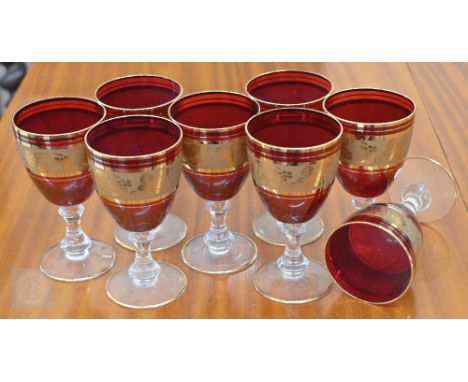 A set of eight Venetian wine glasses with ruby and gilt bowls, 15 cm high