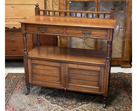 An Edwardian mahogany buffet with two drawers and panelled cupboard doors on turned legs and casters, 106 x 46 x 105 cm high