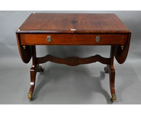 A Regency cross-banded satinwood sofa table, the drop leaf top over two frieze drawers and opposing dummy drawers, raised on 