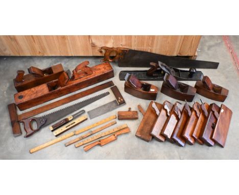 A collection of traditional woodworkers hand tools incl. a large antique stained wood smoothing plane, 62 cm long, to/w a Bai