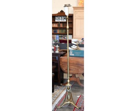 A polished brass standard lamp on scrolling triform base with Neoclassical ribbon swags, 180 cm h