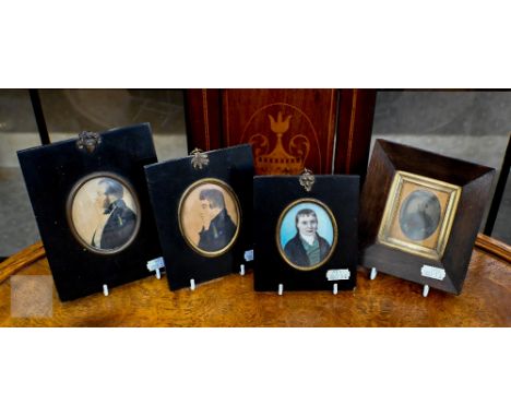 An early 19th century oval portrait miniature on ivory of a gentleman, to/w two watercolour profile portrait miniatures and a