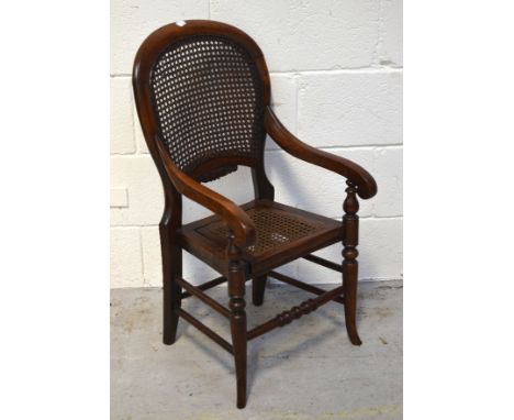 An Edwardian child's mahogany commode with bergère back and seat.