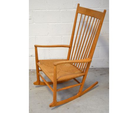 Hans Wegner for F D B Mobler; a retro stick back rocking chair with rush seat, bearing label to underside on one armrest.    