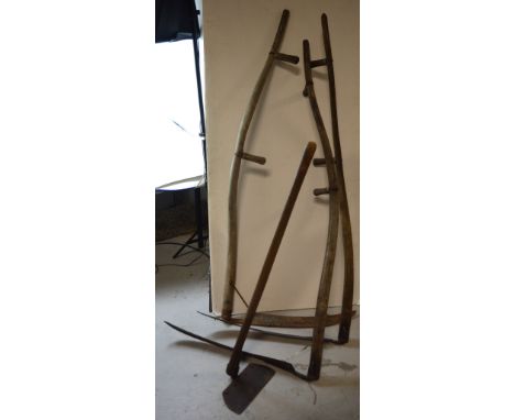 Three scythes and a further wooden-handled agricultural tool (4).