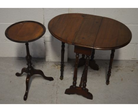 A mahogany drop-leaf table of small proportions, raised on turned supports with castors, height approx 52cm, width when exten