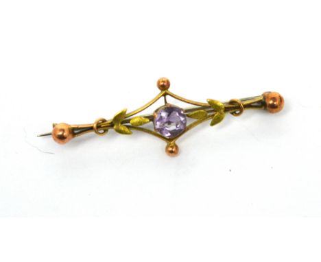 An Edwardian 9ct gold bar brooch with central amethyst-coloured stone and leaf decoration, approx 2.1g.