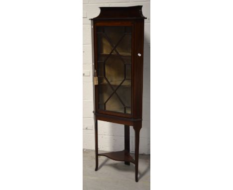 An Edwardian mahogany inlaid corner display cabinet with three interior shelves and astragal glazed door, raised on three tap