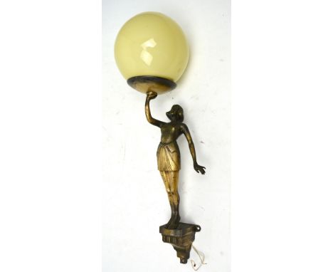 An Art Deco wall light in the form of a young woman holding a glass spherical globe shade, height 47cm inclusive of shade.   