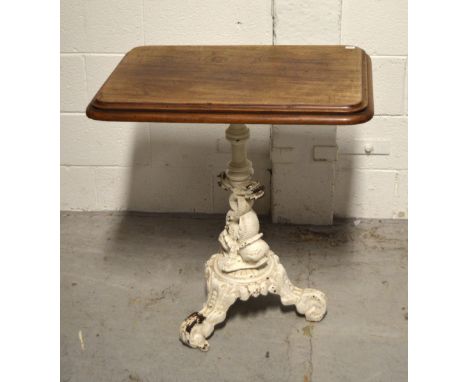 A walnut and white painted cast iron table raised on elaborate tripod support, width 69cm.