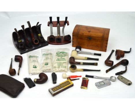 A quantity of vintage pipes, pipe racks and lighters, part-contained within a cigar box.