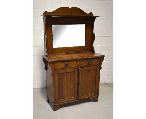 An Art Nouveau style oak mirror back sideboard, bevel edged rectangular plate above two short drawers and a twin-door cupboar