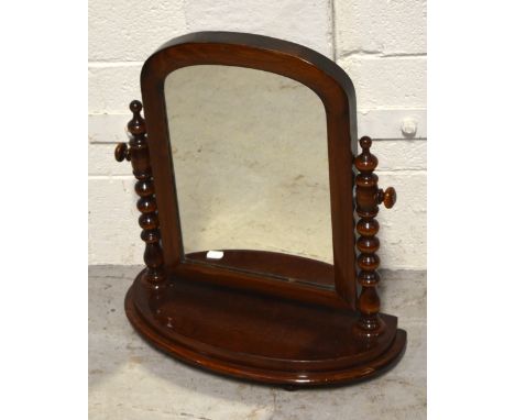 A mid-Victorian mahogany tabletop swing mirror, raised on bobbin supports on demi-lune base, height 53cm, width 45cm.