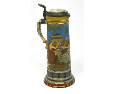 A large Mettlach tankard with hinged pewter and ceramic lid, height 40cm.   CONDITION REPORT  There is a crack and repair to 