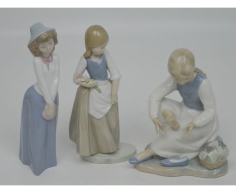 Three Nao figures; a boy, a girl and a larger example of a seated young lady rubbing her feet (3).