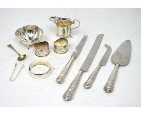 A quantity of hallmarked silver to include a small bowl raised on four paw supports, a similar jug, two napkin rings, a pair 