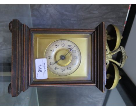 An Edwardian walnut table alarm clock surmounted by twin bells with silvered chapter ring. 25cm high 