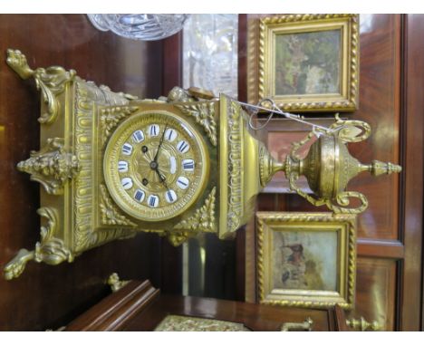 A late 19th century French brass mantel clock, with repeat mechanism, the square case surmounted by a trophy, with lion mask 