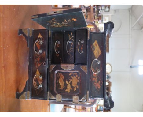A Japanese lacquer table cabinet, with frieze drawer over cupboard doors and long drawer on bracket feet, 34cm high