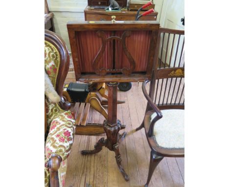 A Victorian rosewood music stand, formerly a duet stand, with lyre shape rest on a hexagonal and lobed stem with tripod base,