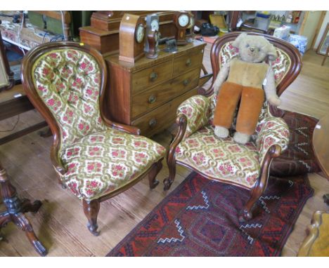 A pair of mid Victorian mahogany ladies and gents salon chairs, the spoon shape button upholstered backs on cabriole legs and