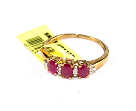 A three stone ruby and diamond ring set in 9 carat gold