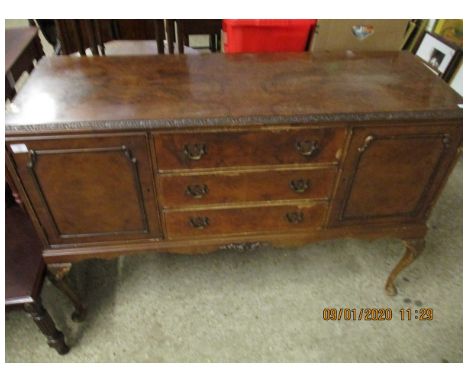 WALNUT SIDEBOARD WITH THREE DRAWERS FLANKED EITHER SIDE BY CUPBOARD DOORS RAISED ON PAD FEET  