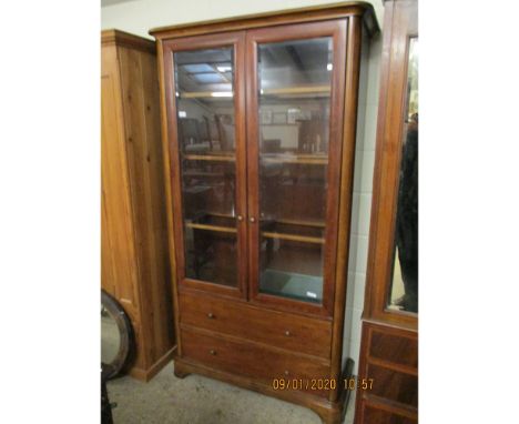 CHERRY WOOD BOOKCASE WITH TWO GLAZED DOORS OVER TWO FULL WIDTH DRAWERS WITH BRASS BUTTON HANDLES  