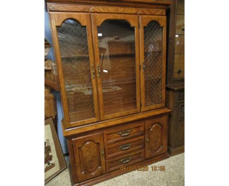 OAK EFFECT BOOKCASE WITH THREE GLAZED DOORS TO TOP, THE BASE FITTED CENTRALLY WITH THREE DRAWERS FLANKED EITHER SIDE BY CUPBO