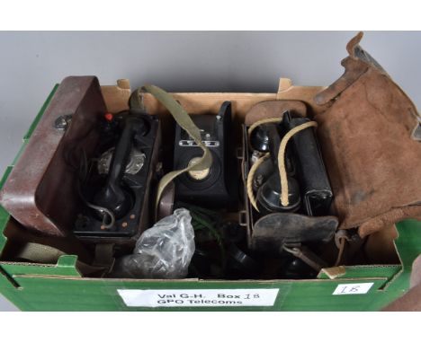 Two cased vintage field telephones, one being a rotary example, together with a vintage black plastic telephone, without reci