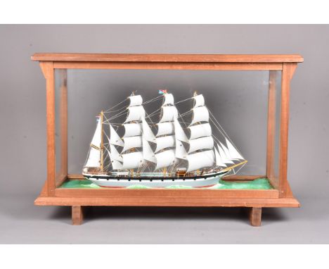 A cased model of a 20th Century Merchant Sailing model, the four-mast model in grey and red, flying various flags, in glazed 