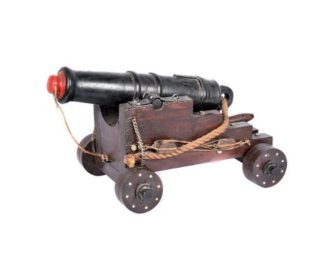 A wooden model of a ship's cannon, possibly a 12 pounder long gun, made by Raymond Arthur Bromley, WWII British Seaman, who s