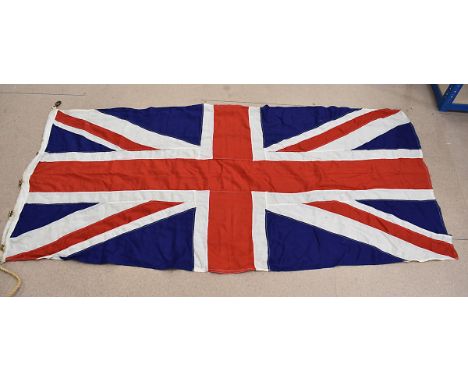 A British Royal Navy ship's Union flag, with brass fixtures to the side, with original rope and metal clasps, stencilling to 