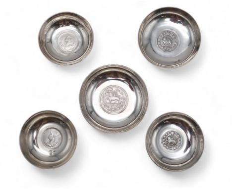 A COLLECTION OF IRANIAN / PERSIAN SILVER COIN DISHES one inset with an Ahmad Shah 2000 Dinar, another with another with a Rez