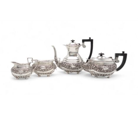 AN EDWARDIAN FOUR PIECE SILVER TEA SERVICE by Levesley Brothers, Sheffield 1902, of baluster form, with embossed scrolling fo
