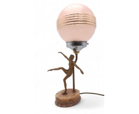 AN ART DECO GILDED SPELTER LADY LAMP modelled with arms and one leg raised, upon onyx base, with mottled pink glass shade, 49