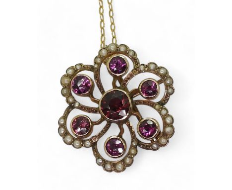 AN EDWARDIAN PENDANT made in 9ct gold and set with garnets and pearls to the classic flower shape, diameter 2.5cm, with a vin